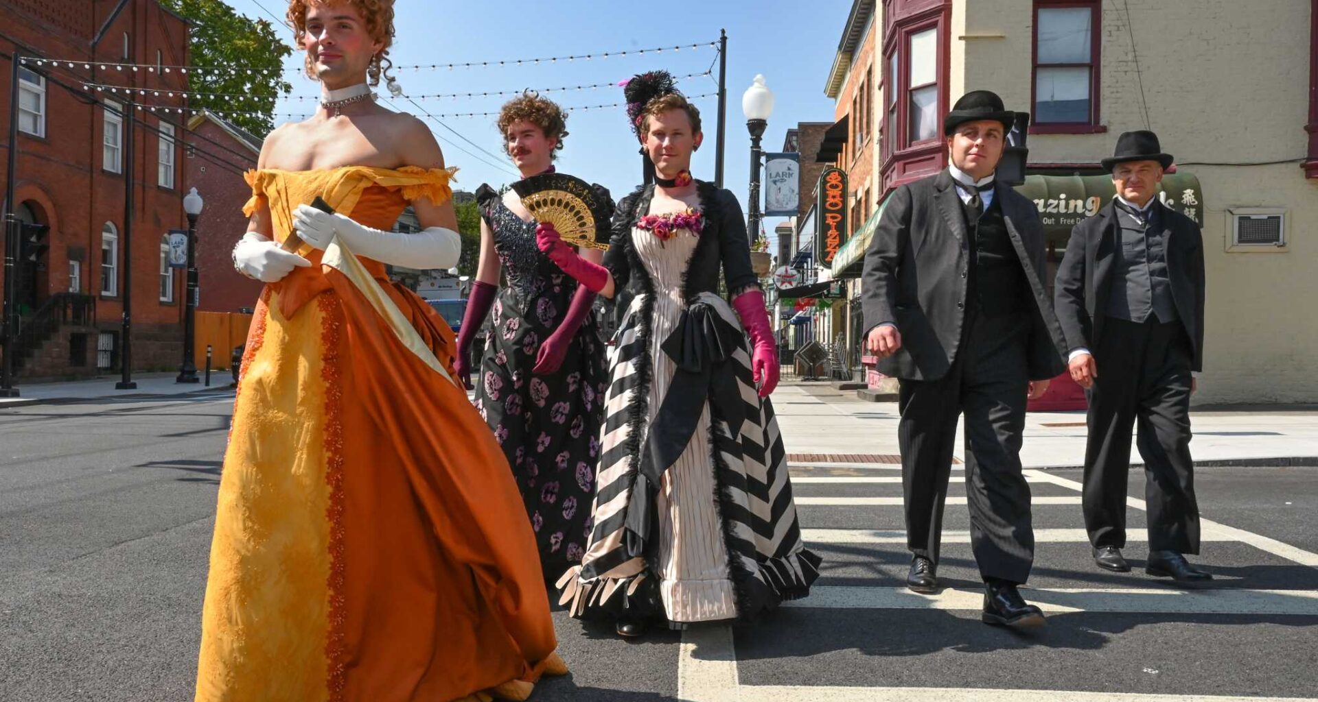 Extras, including three men dressed as woman impersonators, are seen crossing the intersection of Hudson Avenue and Lark Street during the filming of the HBO series “The Gilded Age” on Aug.14, 2024, in Albany. The series will return to the Capital Region in May to film portions of its fourth season.