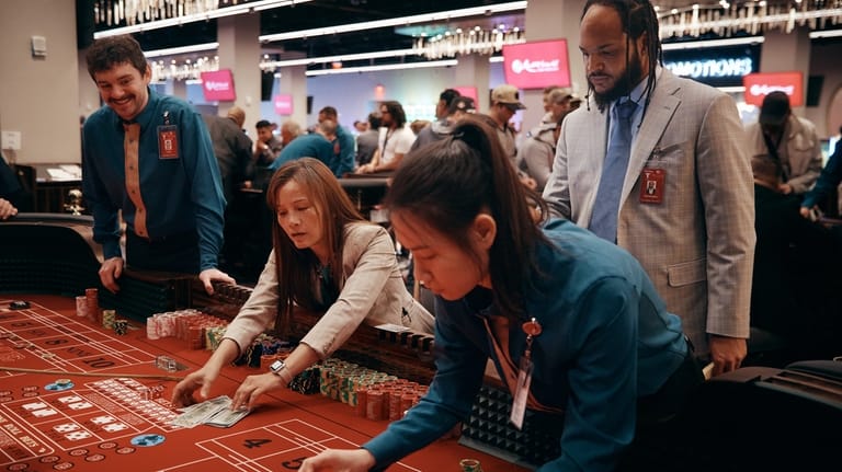dealer removes cash from a craps table during the opening...