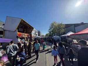 A family is seen near a vendor hosting a ‘pop the balloon’ game, where people could win stuffed animals as prizes. Photo: Kyle Stevens / @ thekylestevens