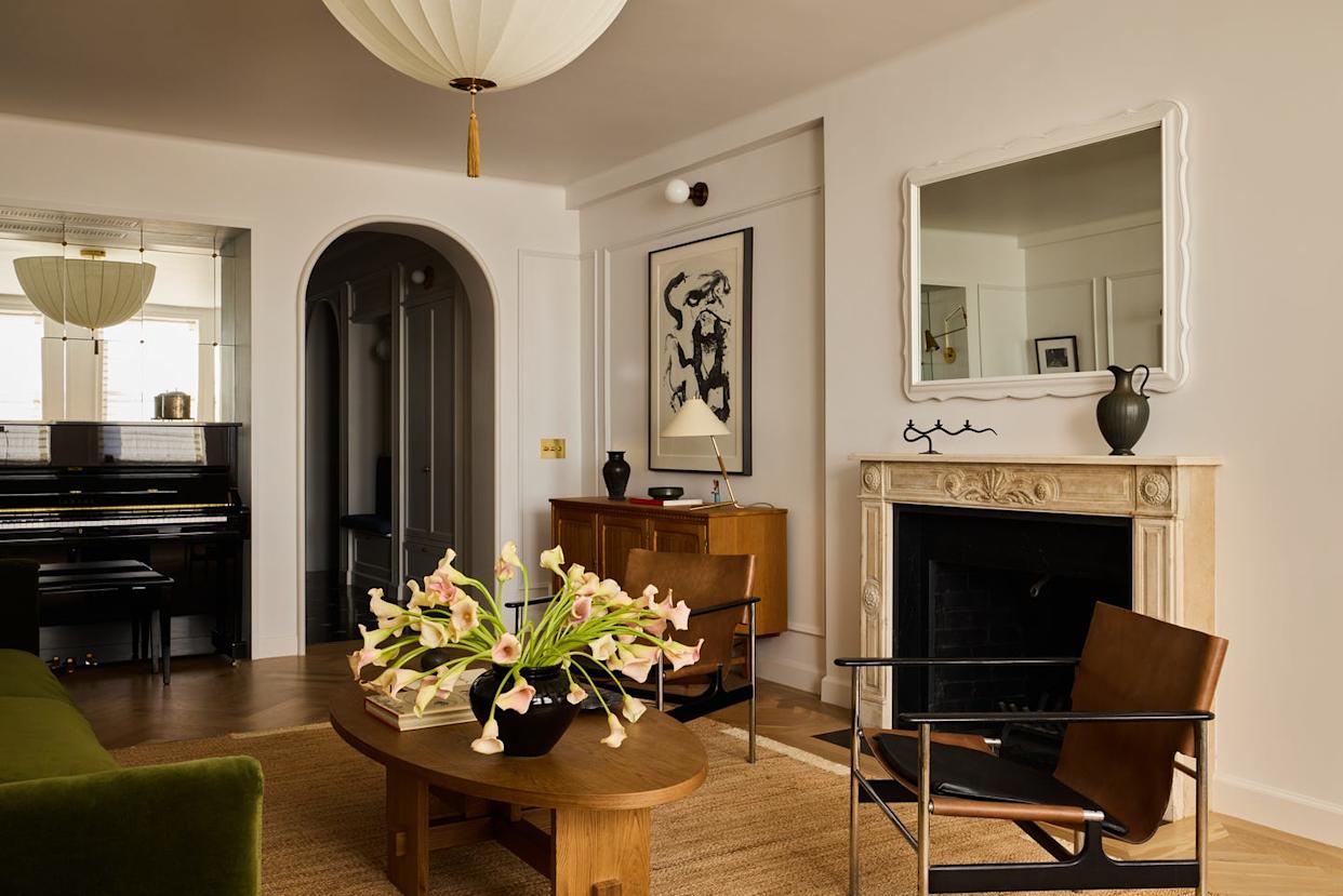 Modern living room with piano, plants, and decorative items.