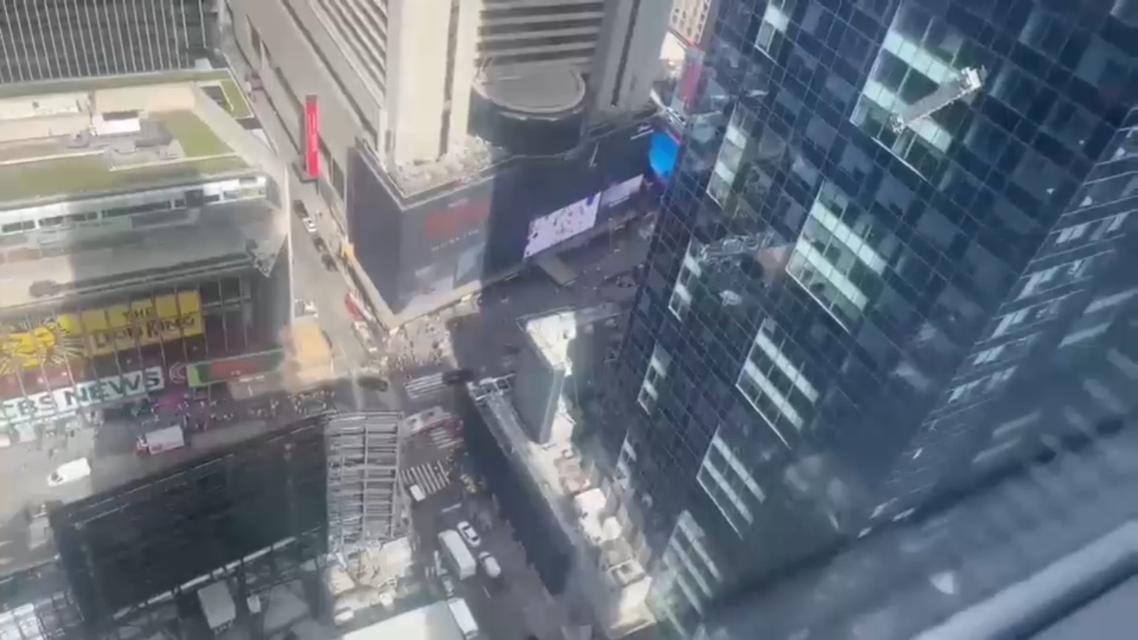 Window washer dangles outside building high above Times Square in NYC