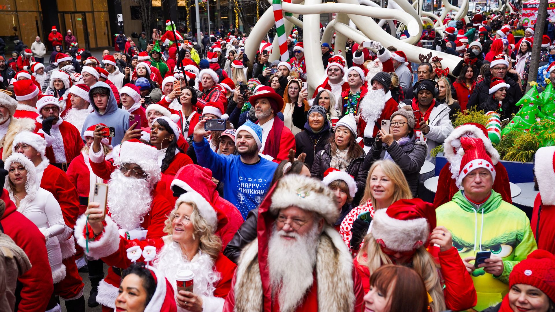 FILE - Revelers dressed as holiday characters participate in the annual SantaCon pub crawl in New York, on Saturday, Dec. 13, 2025.