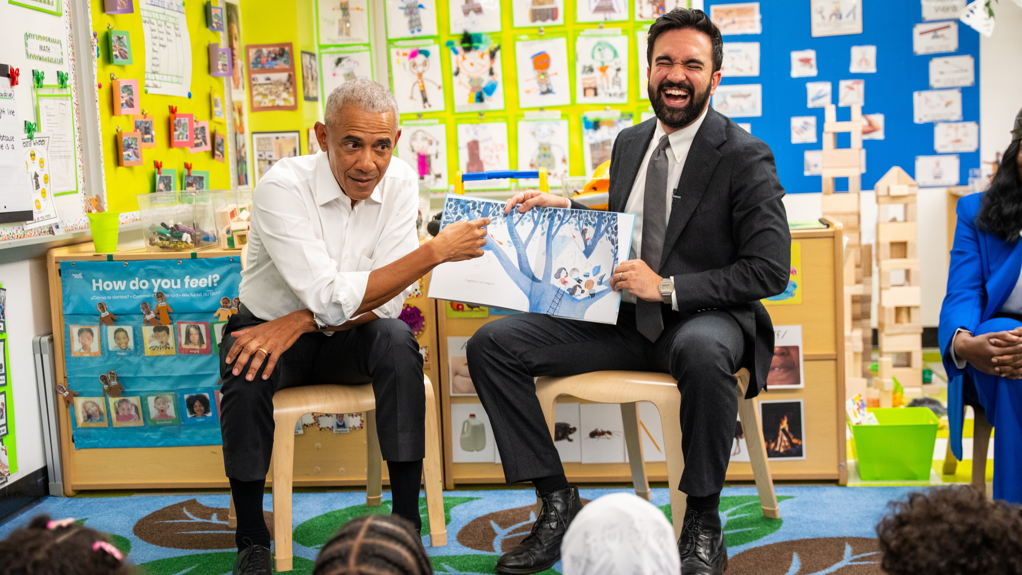 Former President Barack Obama, left, and Mayor Zohran Mamdani read a book to children at Learning Through Play Pre-K in New York, on Saturday, April 18, 2026.