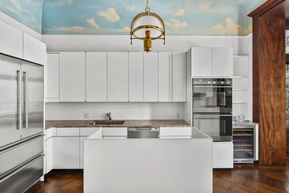 white kitchen with standalone island and stainless double fridge-freezer