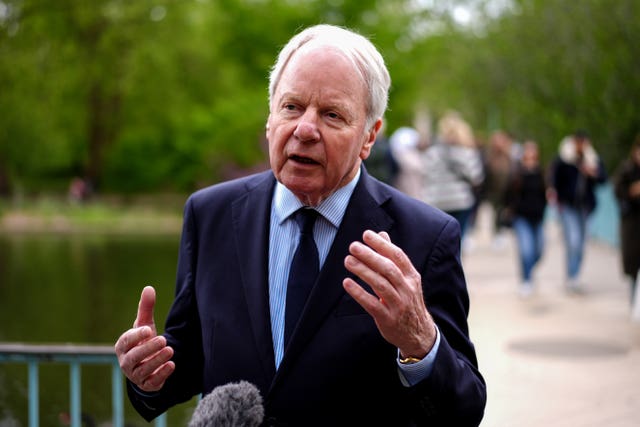 Lord Janvrin gesturing while speaking into a boom mic
