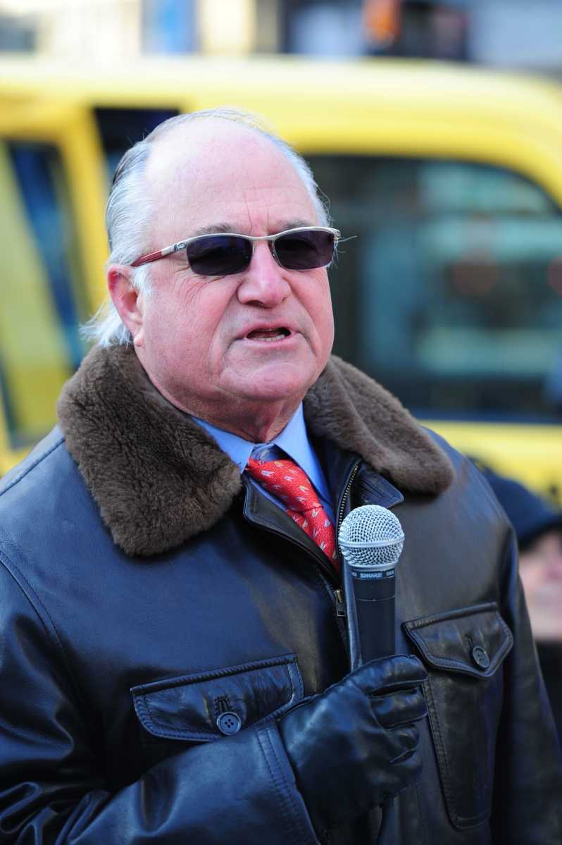 man holding a microphone wearing a jacket and gloves