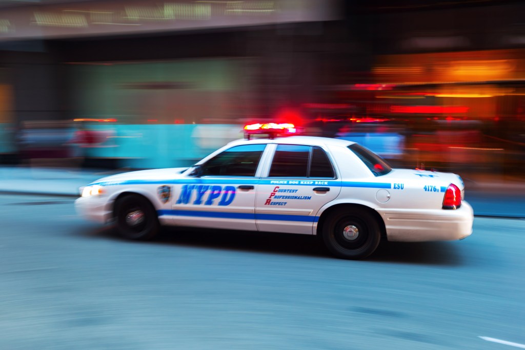 An NYPD car speeds through Manhattan