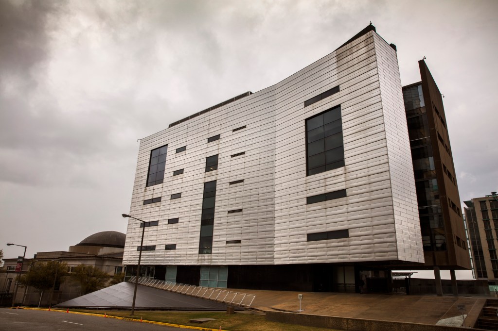 The Southern Poverty Law Center building in Montgomery, Alabama, featuring a modern facade with varying window sizes, under a cloudy sky.