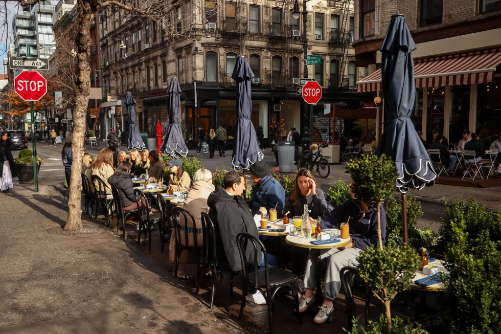 People dining outdoors at a cafe on Orchard Street in New York City.