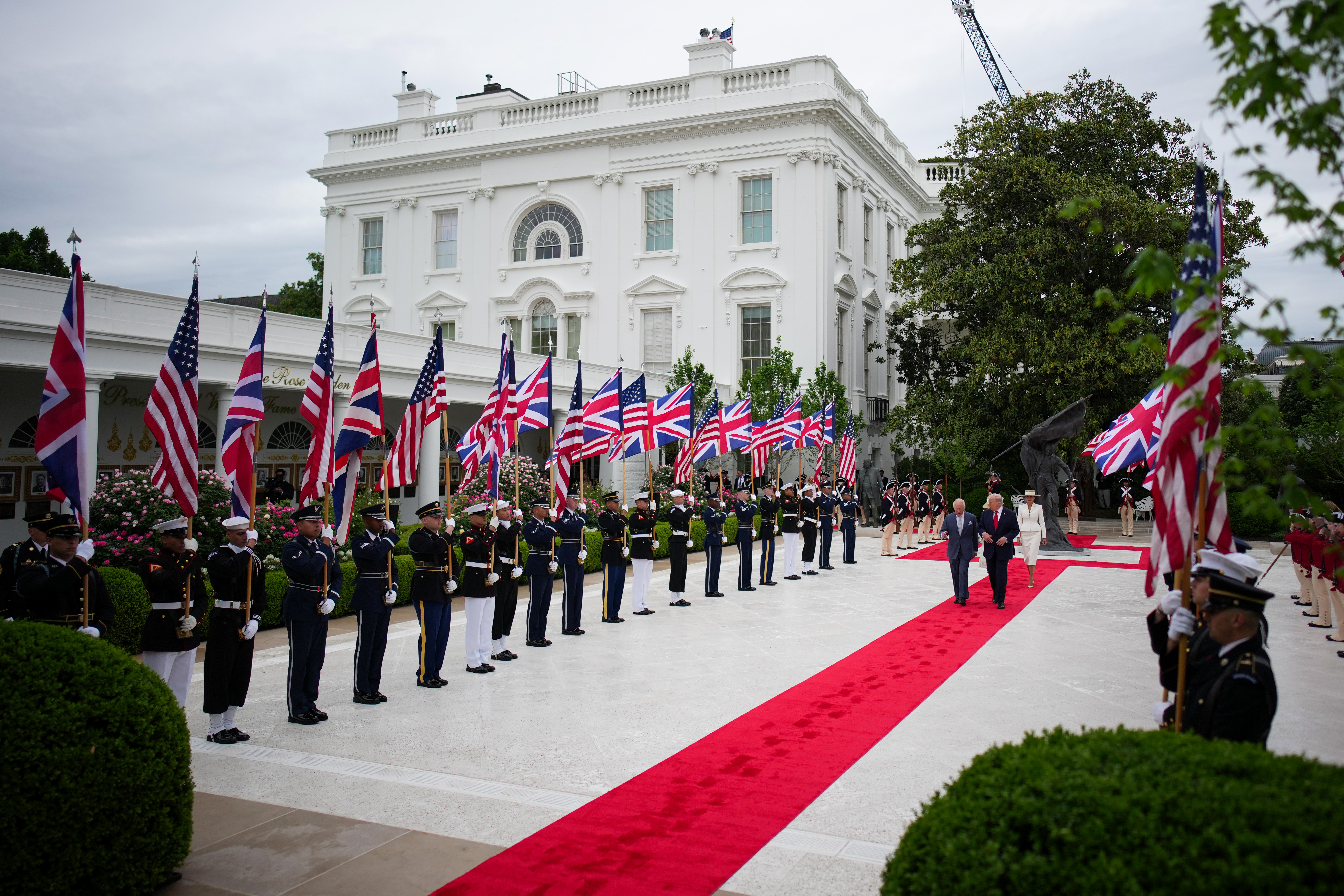 President Donald Trump, Queen Camila and Melania Trump walk in the White House Rose Garden following the state arrival ceremony.