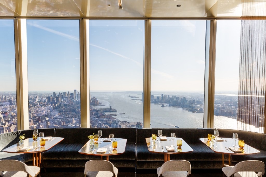 A restaurant with a view of New York City and the Hudson River from high above.