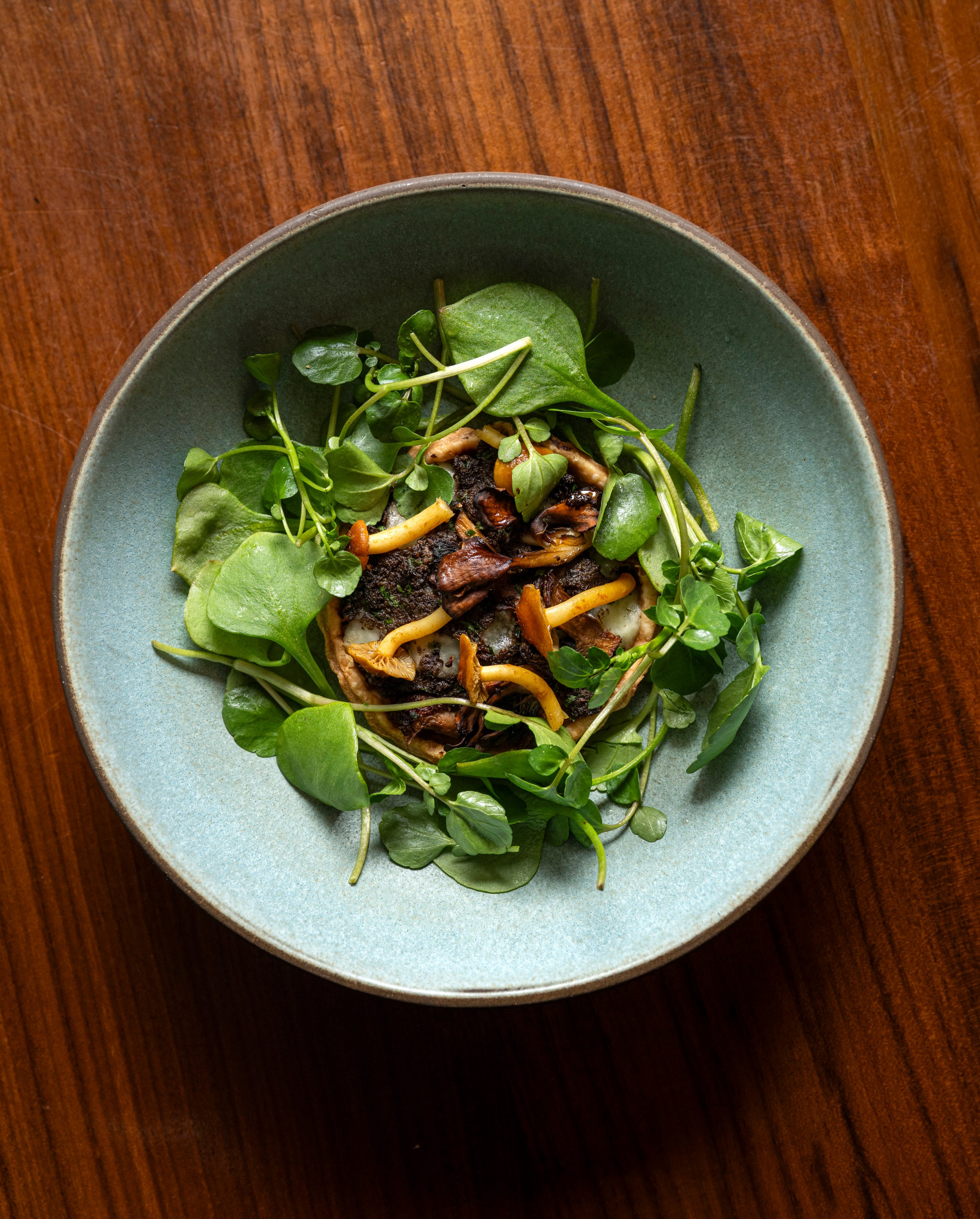 A plate of mushrooms and greens.
