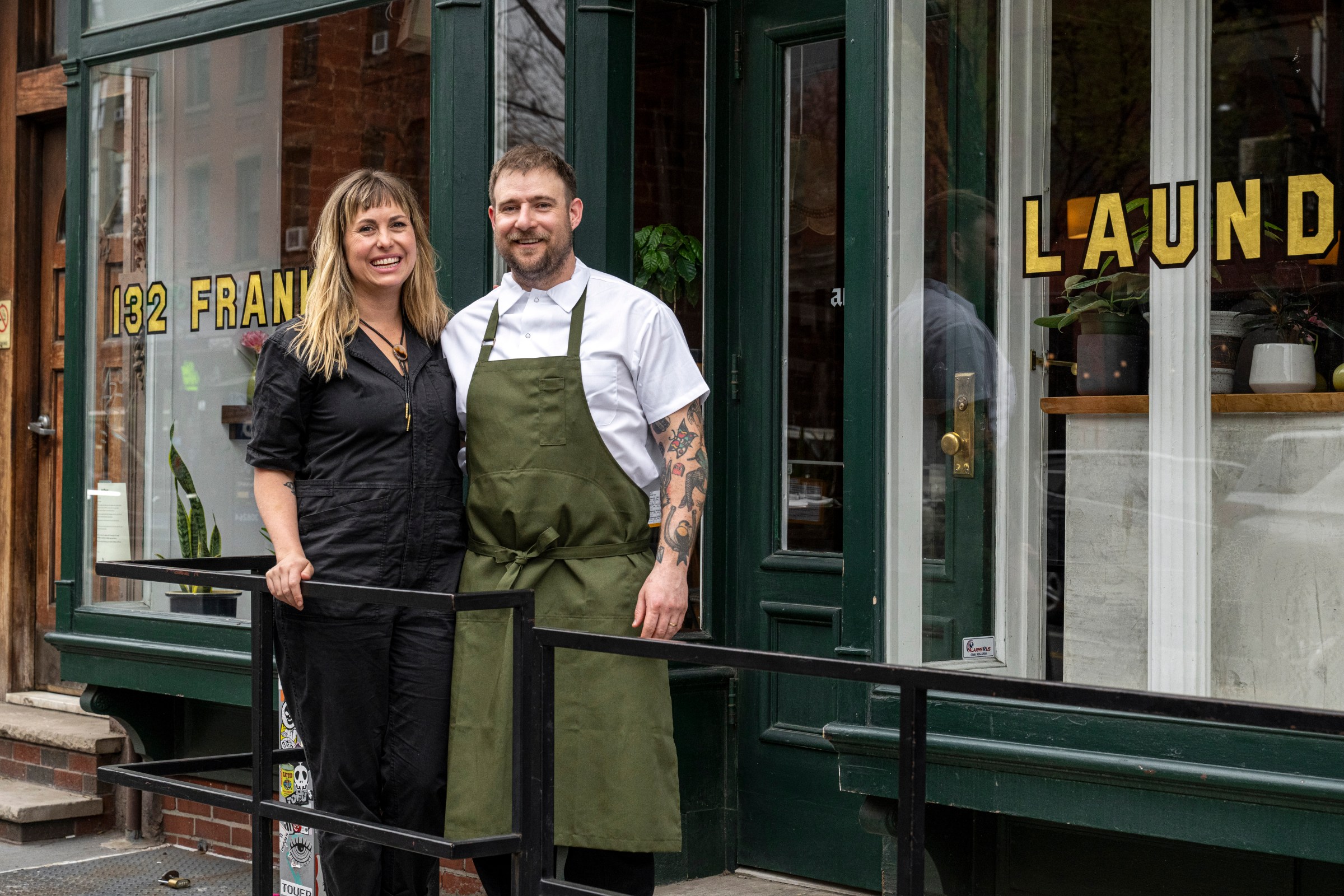 Two people standing in front of a restaurant.