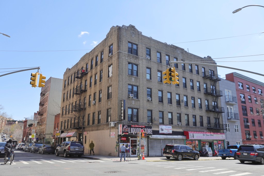 Street view of a large brick apartment building with a liquor store on the ground floor, on 486 East 167th Street in the Bronx, New York.