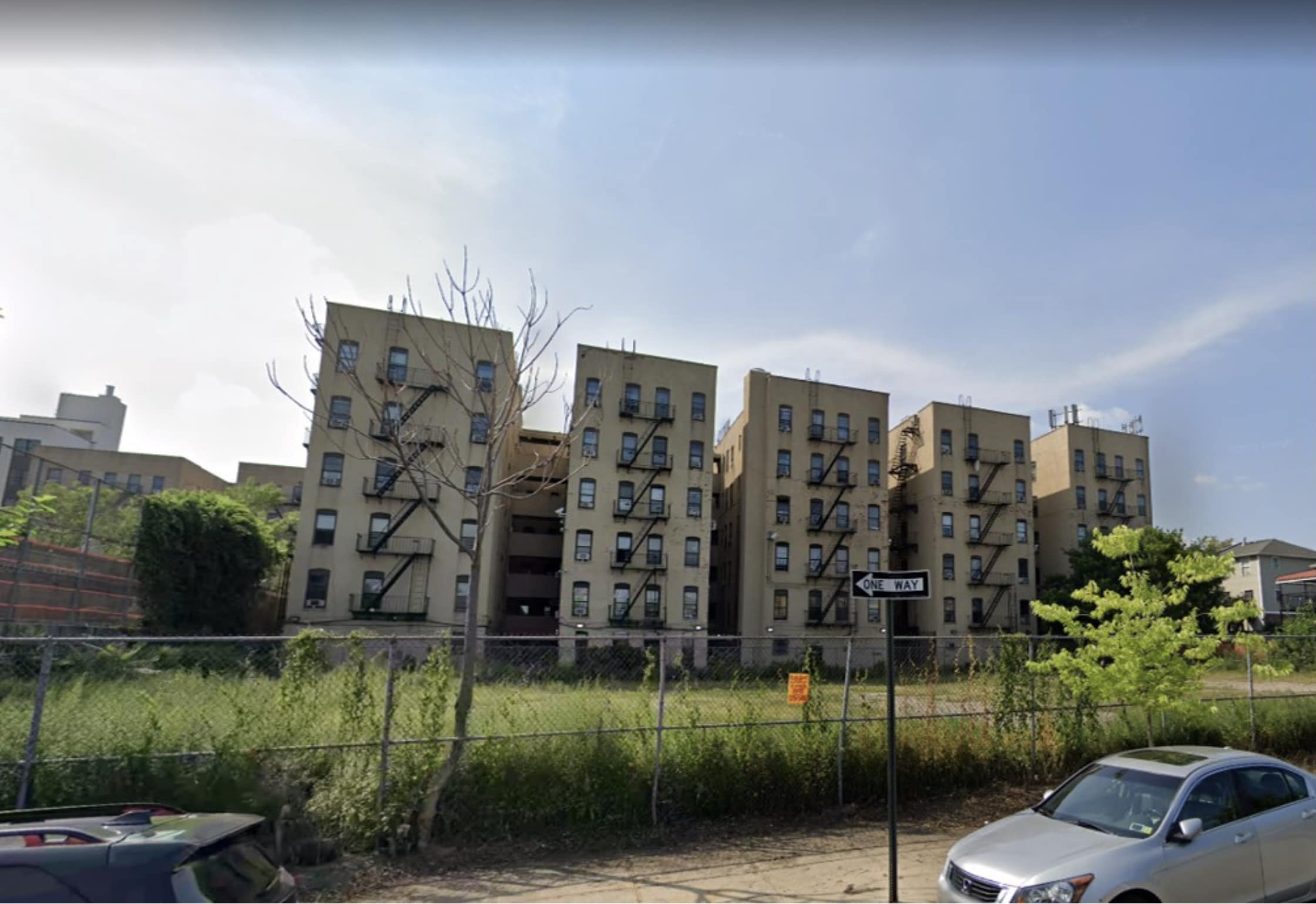 A grassy lot with buildings in the background