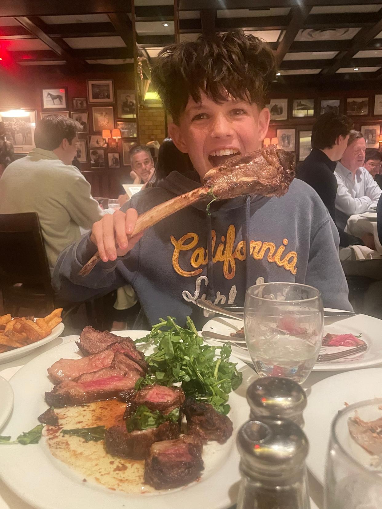 The author's son enjoys a steak dinner in NYC.