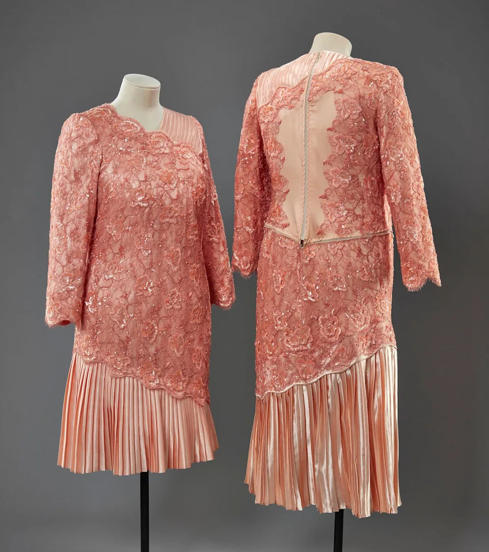 fashion garment displayed on mannequins showcasing intricate lacework and pleated design