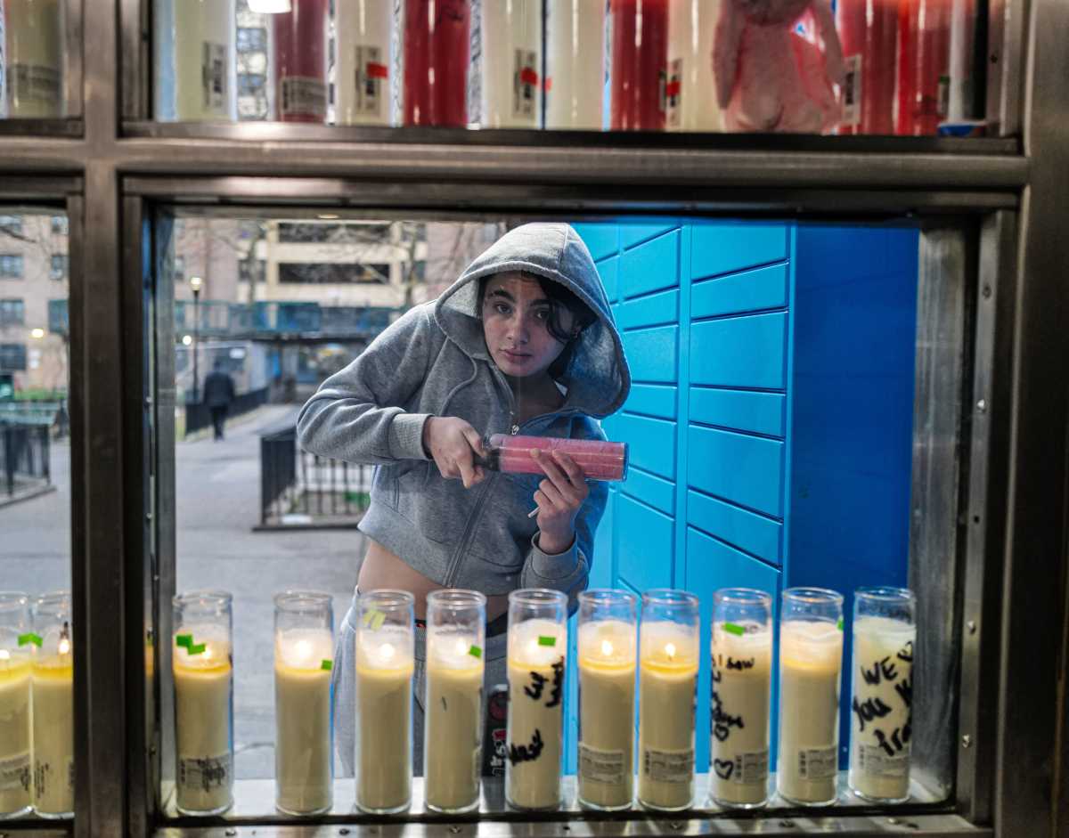 woman at candle lined memorial for victim of brooklyn shooting