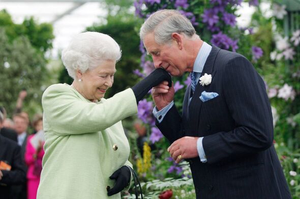 Queen Elizabeth II presents Prince Charles