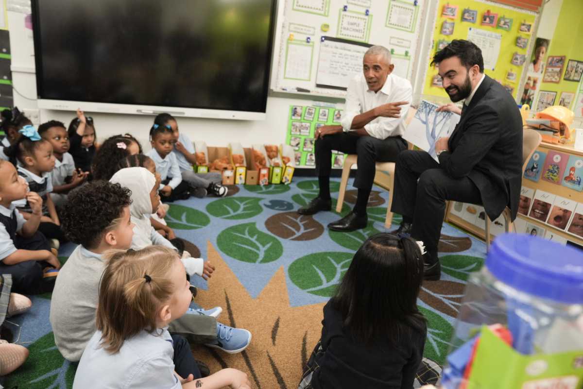 President Barack Obama and Mayor Zohran Mamdani smiling while sitting and talking with kids about childcare