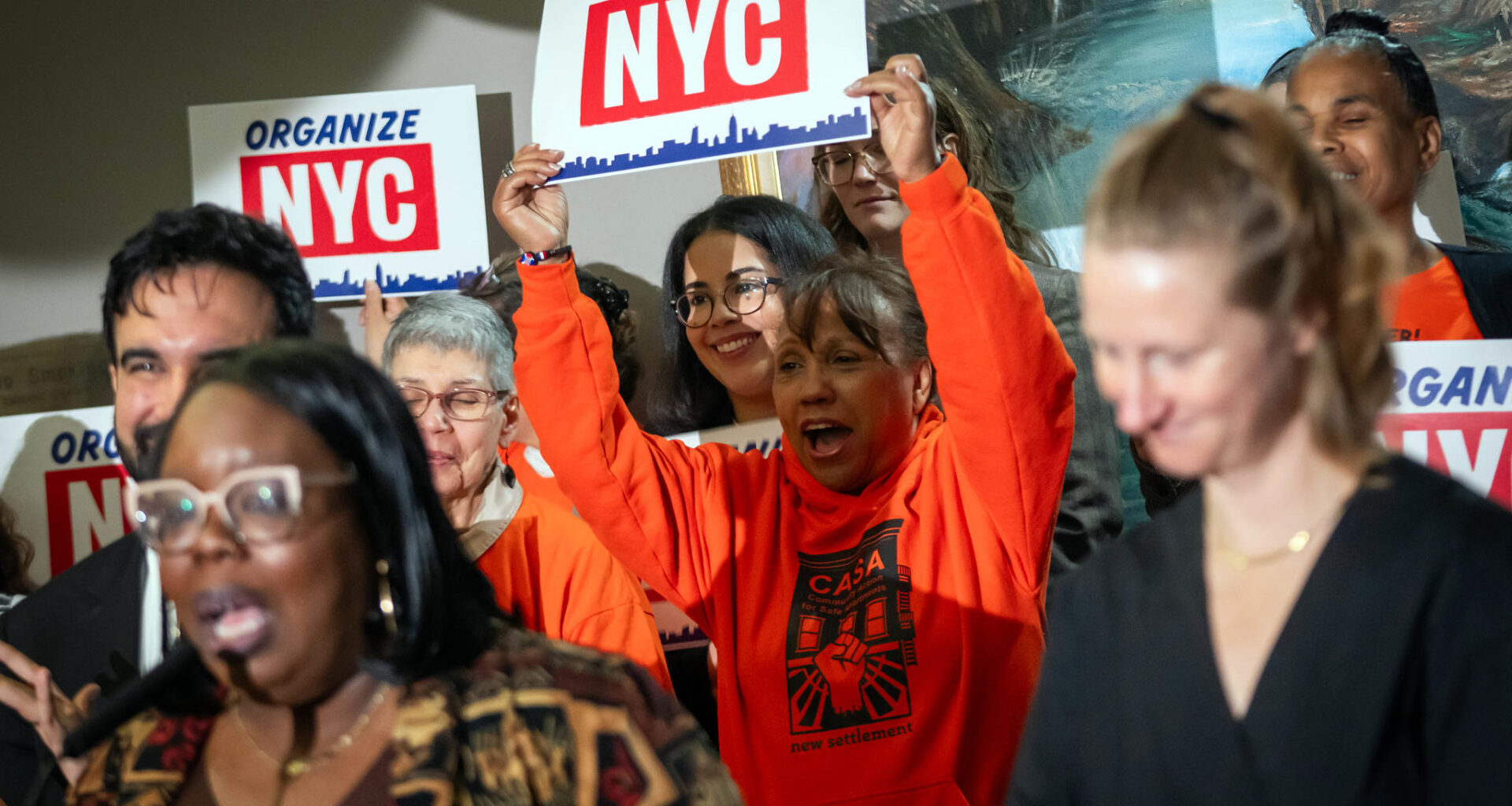 Atendees hold up signs at Wedensday's press conference. Photo: Ed Reed/Mayoral Photography Office
