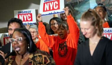 Atendees hold up signs at Wedensday's press conference. Photo: Ed Reed/Mayoral Photography Office