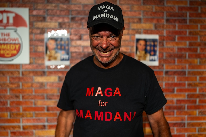 A man in a MAGA for Mamdani t-shirt and hat.