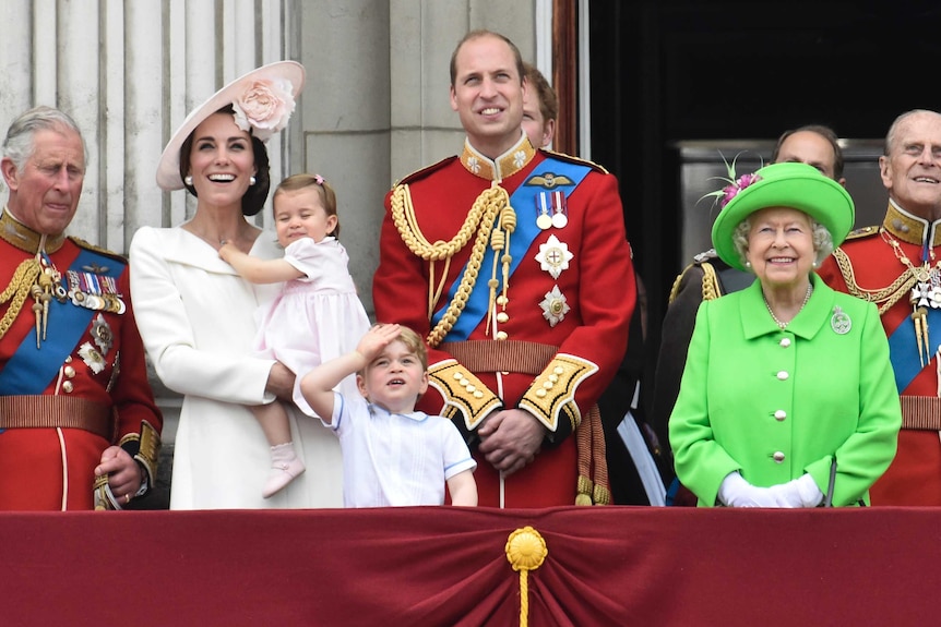 Queen Elizabeth and other members of the royal family stand on the balcony of Buckingham Palace.