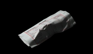 An extreme close-up of a crumpled financial document or ledger page reflecting a harsh, direct camera flash, conceptually representing the alleged financial ties between Wexner and Epstein