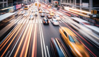 An abstract, blurred image of a busy New York City street, with streaks of vibrant color and motion representing the energy and complexity of urban traffic.