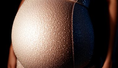 An extreme, abstract close-up photograph of a shimmering, glittering baby bump, captured in dramatic, high-contrast studio lighting to create a glitzy, high-fashion aesthetic.