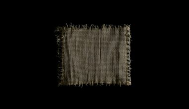 An extreme close-up photograph of a single piece of burlap fabric, capturing the rough, textured material in dramatic lighting that evokes a sense of the gritty investigation into the Gilgo Beach serial killings.