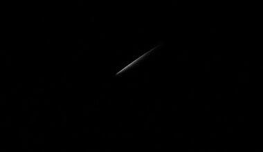 An extreme close-up of a single knife blade partially obscured by shadows, creating a stark, gritty, investigative aesthetic through the use of harsh, direct flash lighting against a pitch-black background.