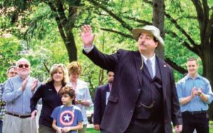 Flag Day, 2017, Bill is on the far left clapping as President Teddy Roosevelt made a guest appearance at the Forest Hills Gardens Flag Day Celebration in honor of the 100th Anniver­sary of TR’s famous speech made at Station Square in For­est Hills. Professor Coleman is seen here with then-Queens Borough President Melinda Katz and her son Carter Katz and Assemblyman Andrew Hevesi.
