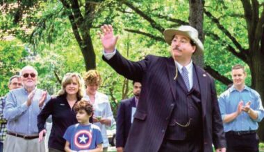 Flag Day, 2017, Bill is on the far left clapping as President Teddy Roosevelt made a guest appearance at the Forest Hills Gardens Flag Day Celebration in honor of the 100th Anniver­sary of TR’s famous speech made at Station Square in For­est Hills. Professor Coleman is seen here with then-Queens Borough President Melinda Katz and her son Carter Katz and Assemblyman Andrew Hevesi.