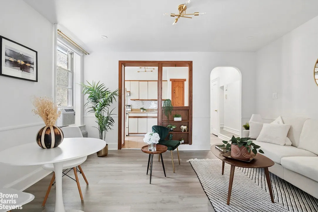 white living and dining area with wood doorway sunset park