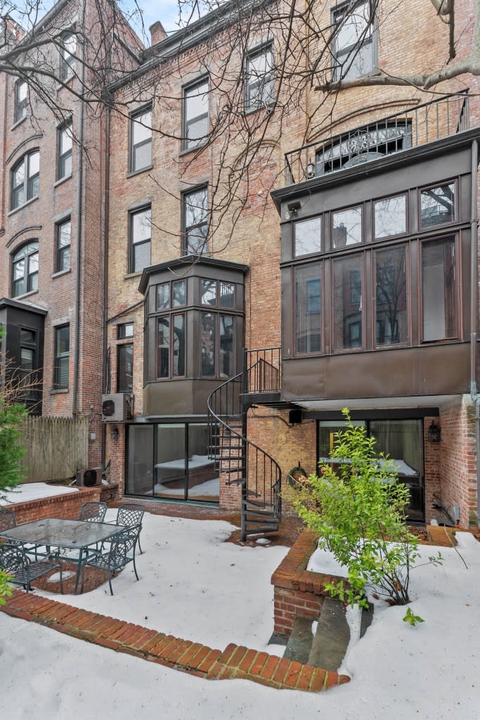 Spiral stairs lead to a rear garden and a brick patio. Platinum Forbes Global Properties