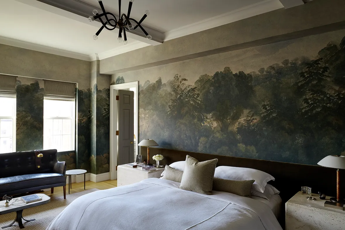 A bedroom featuring walls painted with a dark, muted landscape of trees and sky.