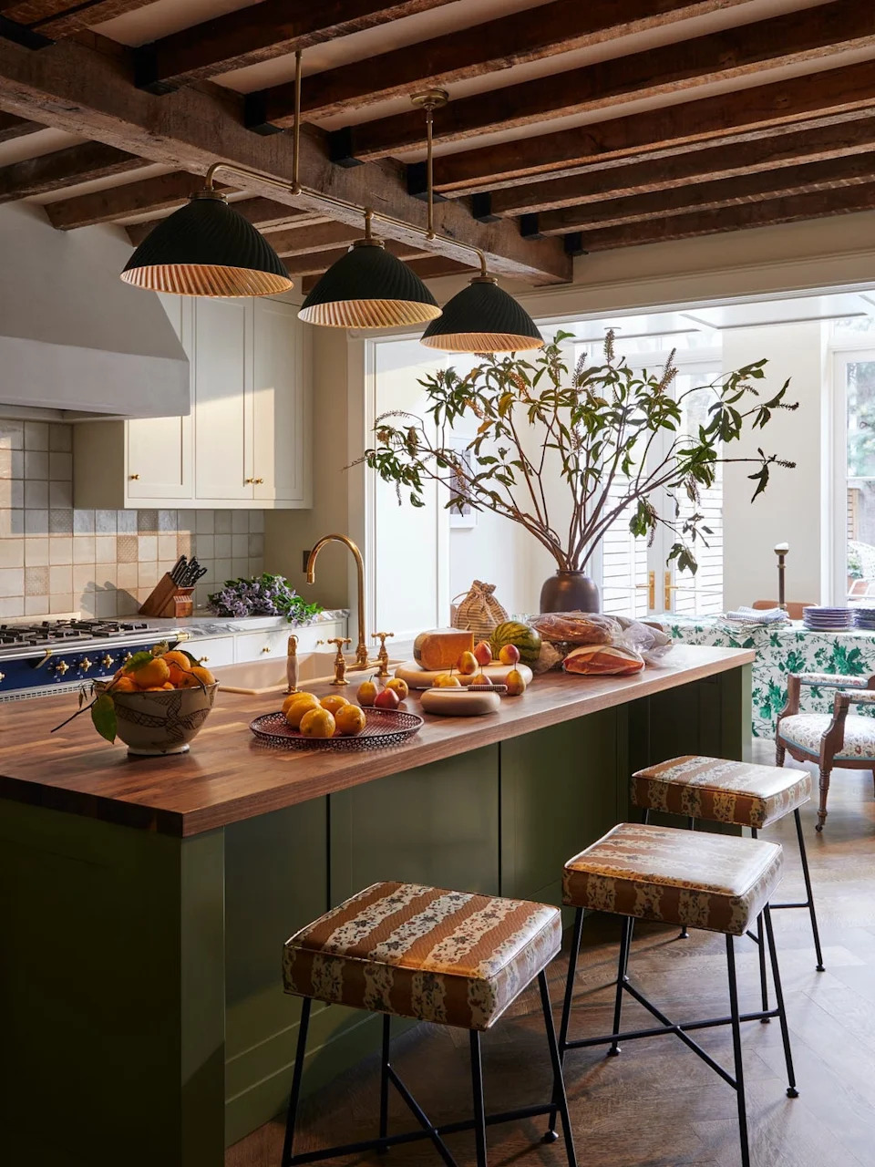 Modern kitchen with fruit display and seating area.
