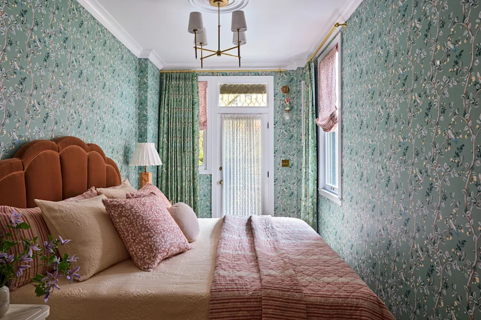 The pattern-drenched bedroom is a jewel box, centered on a king-size Arhaus bed dressed in a Nickey Kehoe coverlet and shams, plus an ABC Carpet & Home quilt—and not much else. “Because it is so tiny, we were like, ‘Let’s just fill up the space,’” says Weed. Coordonné wallpaper and matching drapes, printed with painterly branches dotted with birds, envelop the room. “It’s such a serotonin boost to go to sleep in a little viney bird nest,” she adds. A vintage flamingo wall sconce from Etsy—one of the first pieces sourced for the apartment—hangs beside the French door to the backyard.