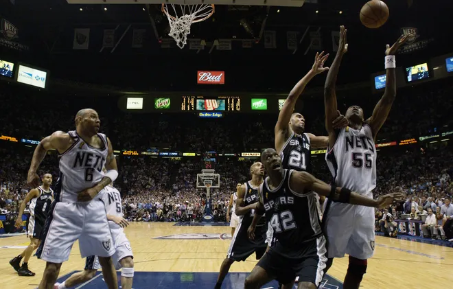 EAST RUTHERFORD, NJ - JUNE 11: Dikembe Mutombo #55 of the New Jersey Nets goes up for a rebound against Tim Duncan #21 of the San Antonio Spurs in Game four of the 2003 NBA Finals at Continental Airlines Arena on June 11, 2003 in East Rutherford, New Jersey. The Nets won 77-76. NOTE TO USER: User expressly acknowledges and agrees that, by downloading and/or using this Photograph, User is consenting to the terms and conditions of the Getty Images License Agreement.(Photo by: Ezra Shaw/Getty Images)