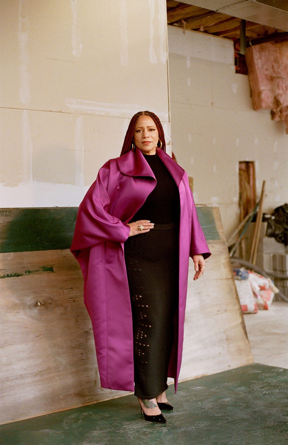 Portrait of a person wearing stylish attire in an unfinished interior space