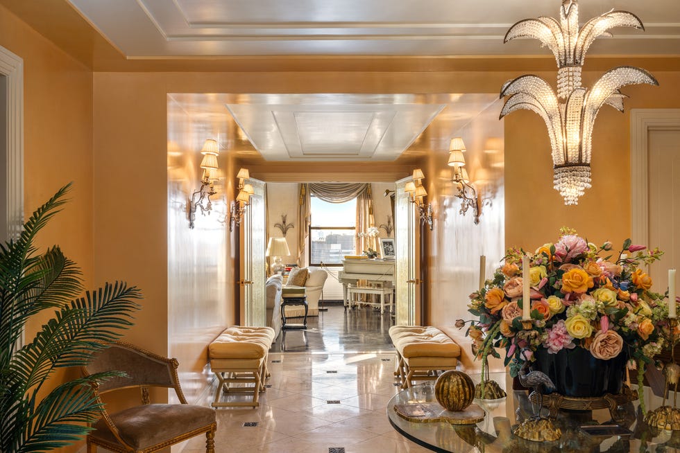 Elegant hallway leading to a living area with floral arrangements and cozy seating.