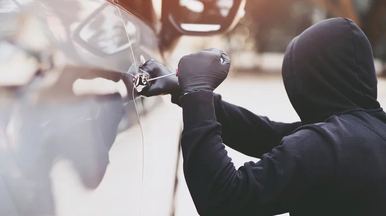 A person breaking into a vehicle.
