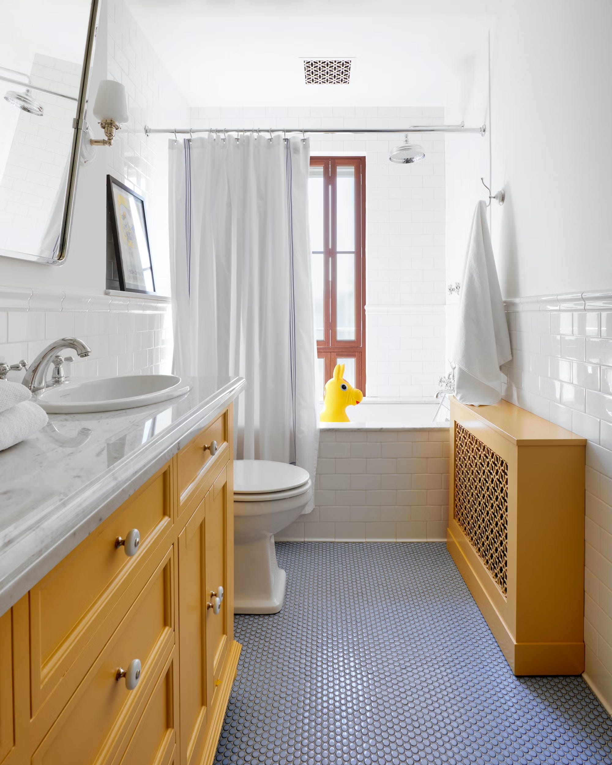 Functional bathroom featuring a yellow cabinet, bath area, and decorative elements.