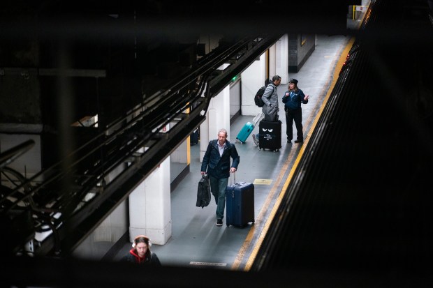 Travelers board their trains for departing at Penn Station in New York, Thursday, Dec. 21, 2023. (AP Photo/Eduardo Munoz Alvarez)