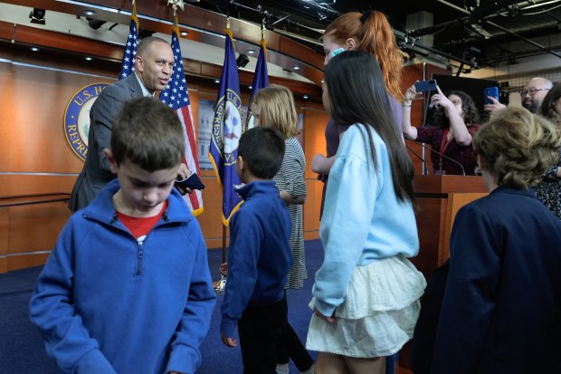 House Minority Leader Hakeem Jeffries, D-N.Y., gives coins to kids after a news conference on Capitol Hill, Thursday, April 23, 2026, in Washington. (AP Photo/Mariam Zuhaib)
