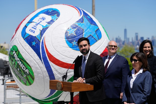 New York City Mayor Zohran Mamdani, left, speaks in front of a large soccer ball the city skyline during a news conference in Staten Island on Monday, April 27, 2026. (AP Photo/Seth Wenig)