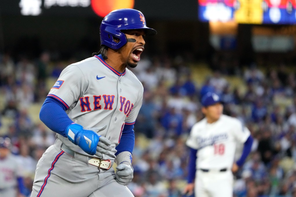 New York Mets' Francisco Lindor, left, celebrates as he heads to first for a solo home run as Los Angeles Dodgers starting pitcher Yoshinobu Yamamoto watches during the first inning of a baseball game Tuesday, April 14, 2026, in Los Angeles. 