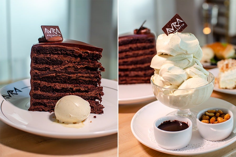 A tall slice of layered chocolate cake with a glossy chocolate topping and a small chocolate square labeled 